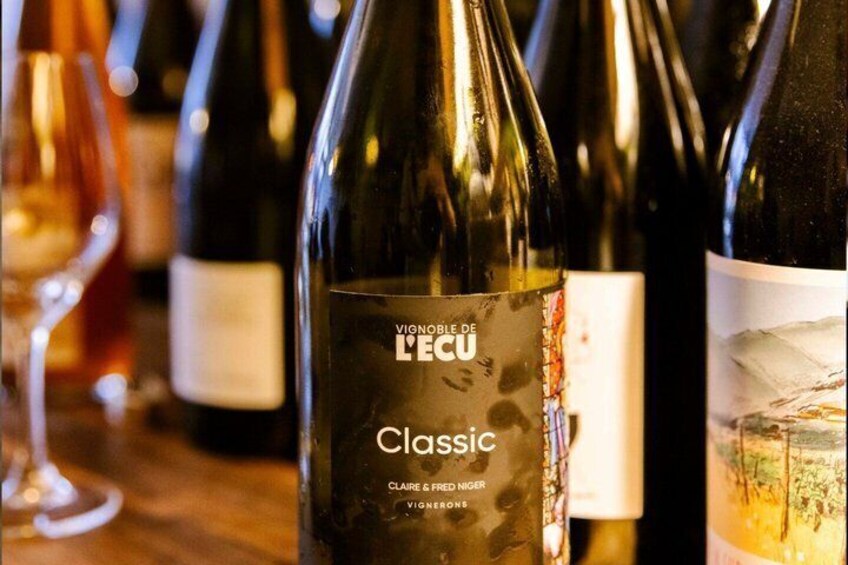 A wine bottle labeled 'Classic' with 'VIGNOBLE DE L'ECO' and 'CLAIRE FRENGER' on it. 3