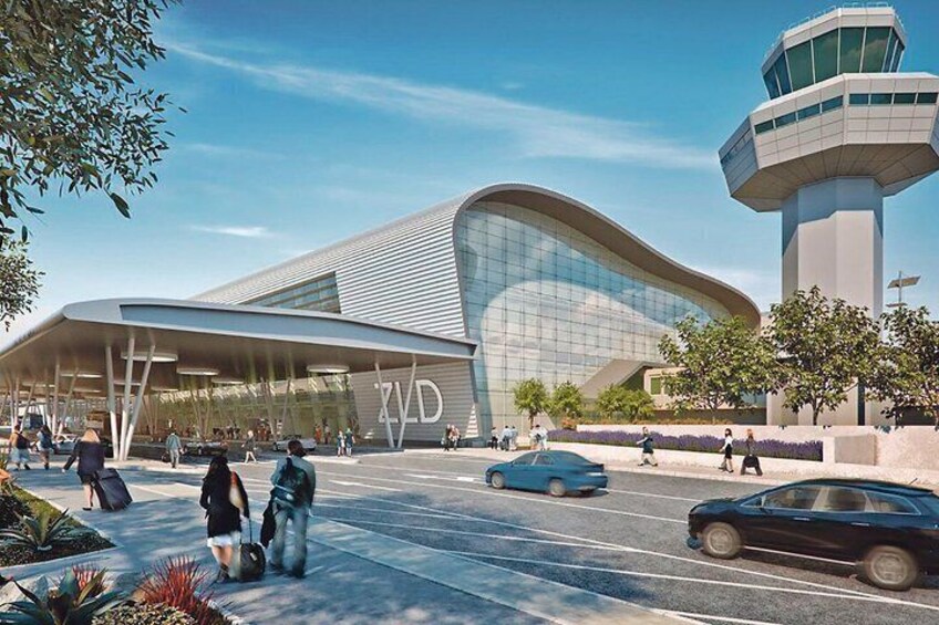 A modern building with a curved facade, a control tower, and people walking in front. 1
