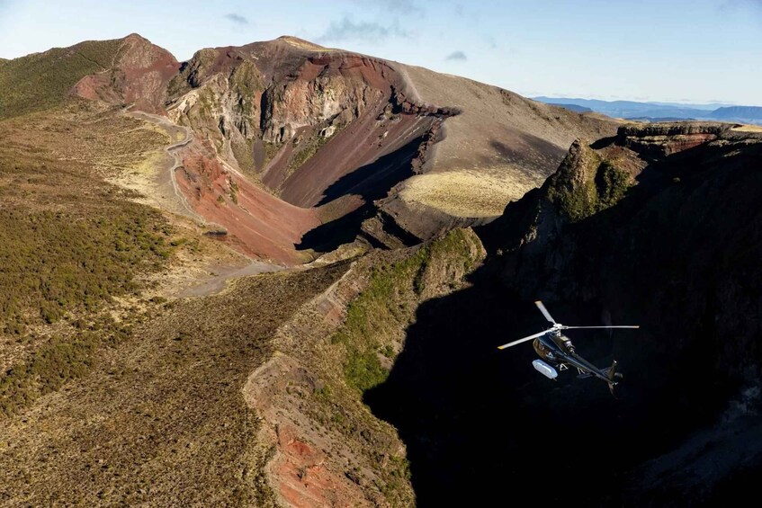 A helicopter flying over a rugged landscape with a large canyon. 4