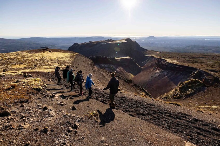 A group of hikers on a rocky mountain trail with a helicopter in the background. 5