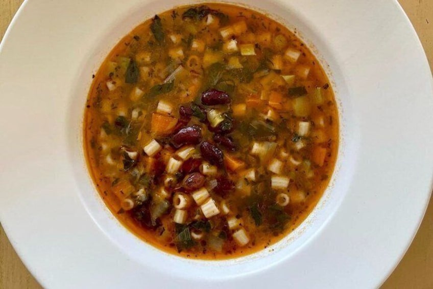 A bowl of vegetable soup with beans, carrots, and celery. 3