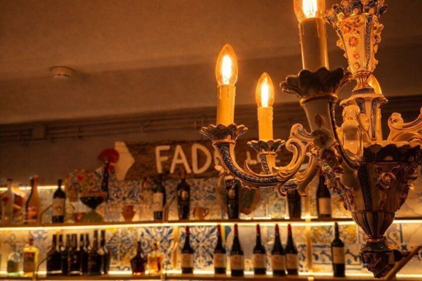 A bar with a decorative candelabra, bottles of wine, and a sign with the letters 'FAD'. 3