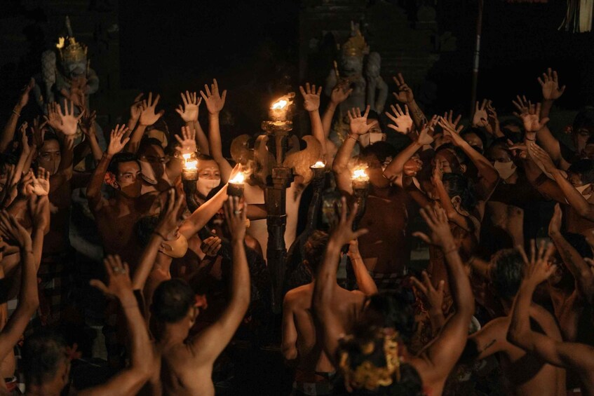 A crowd of people with raised hands and candles. 4