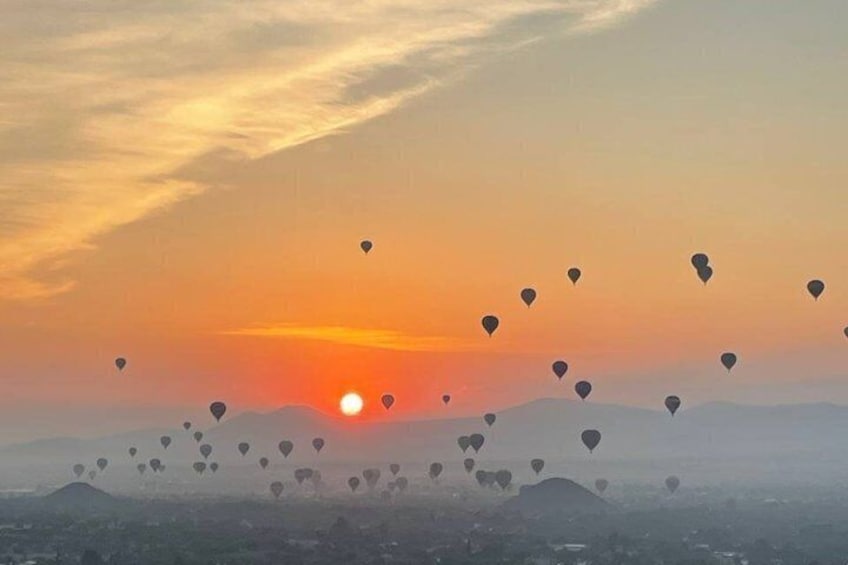 A sunset with hot air balloons in the sky. 2
