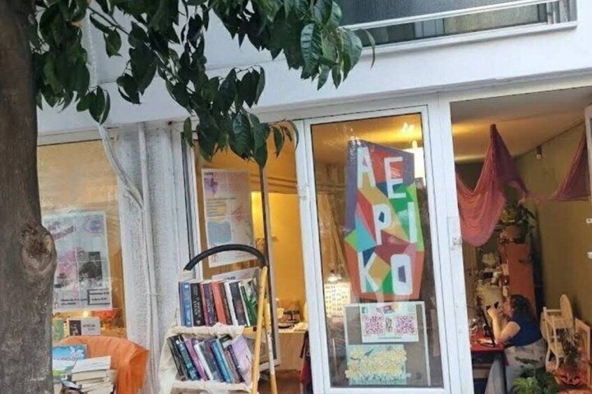 A bookstore with a colorful sign and a display of books outside. 2