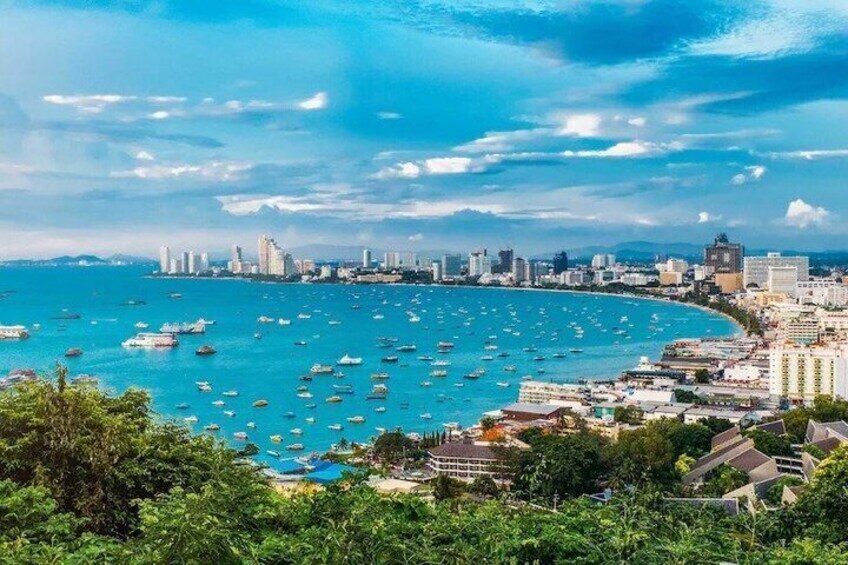A coastal cityscape with a marina filled with boats, a clear blue sea, and a skyline of buildings. 3