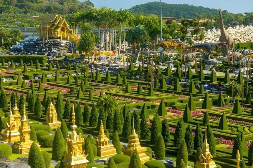A meticulously landscaped garden with golden structures, a variety of trees, and dinosaur sculptures. 5
