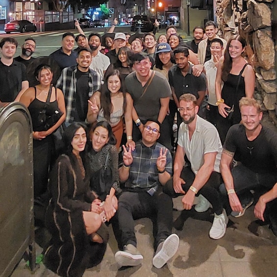A group of people posing for a photo in an urban setting at night. 3