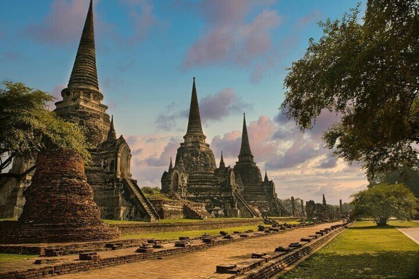 Ancient temple ruins with multiple spires and a well-maintained pathway. 1