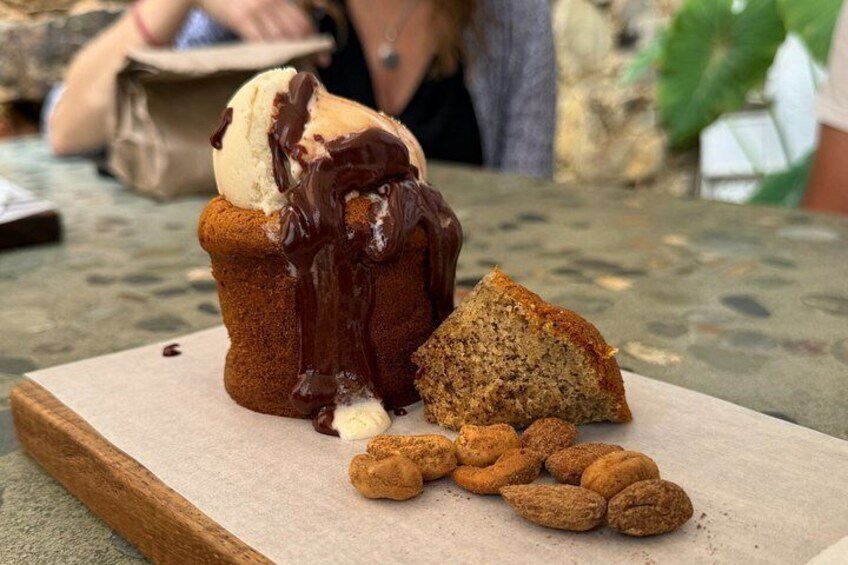 A muffin with chocolate sauce and a scoop of ice cream on a wooden board. 3