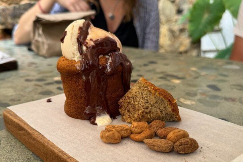 A muffin with chocolate sauce and ice cream, and a slice of muffin on a wooden board. 4