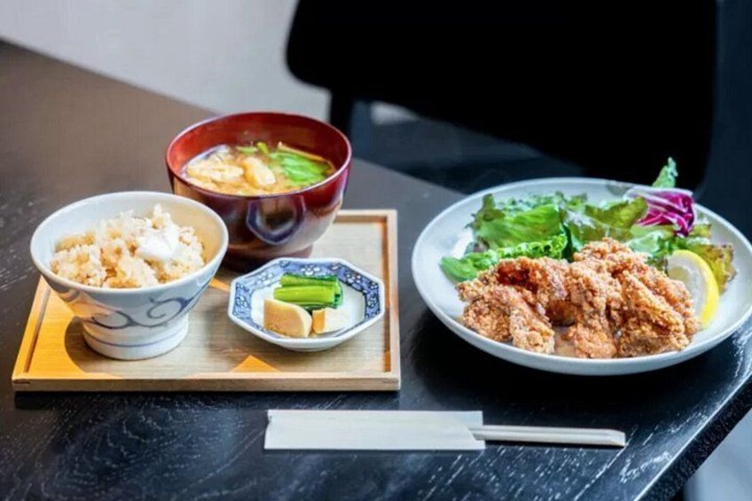 A meal with rice, soup, and fried chicken on a table. 2