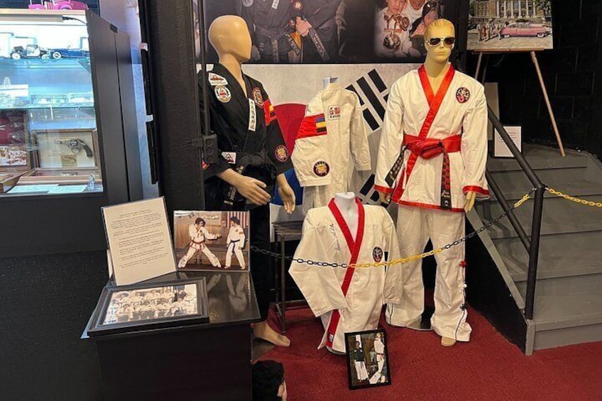 A display with mannequins dressed in martial arts uniforms, a red carpet, and informational panels. 4