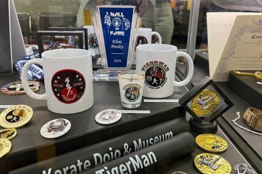 A display of memorabilia and awards, including mugs and medals, with a focus on a tiger-themed collection. 3