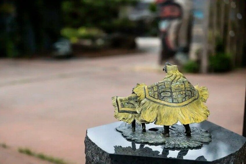 A small statue of a figure with a shield and a hat on a pedestal. 5