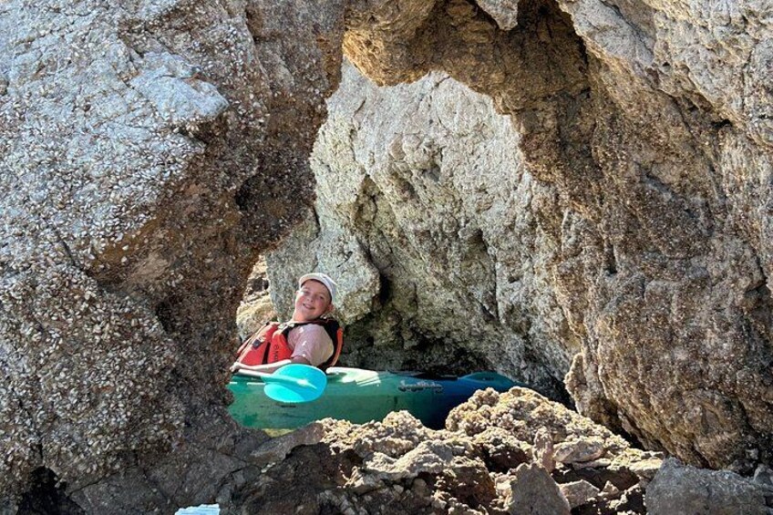 A person in a cave with a kayak. 2
