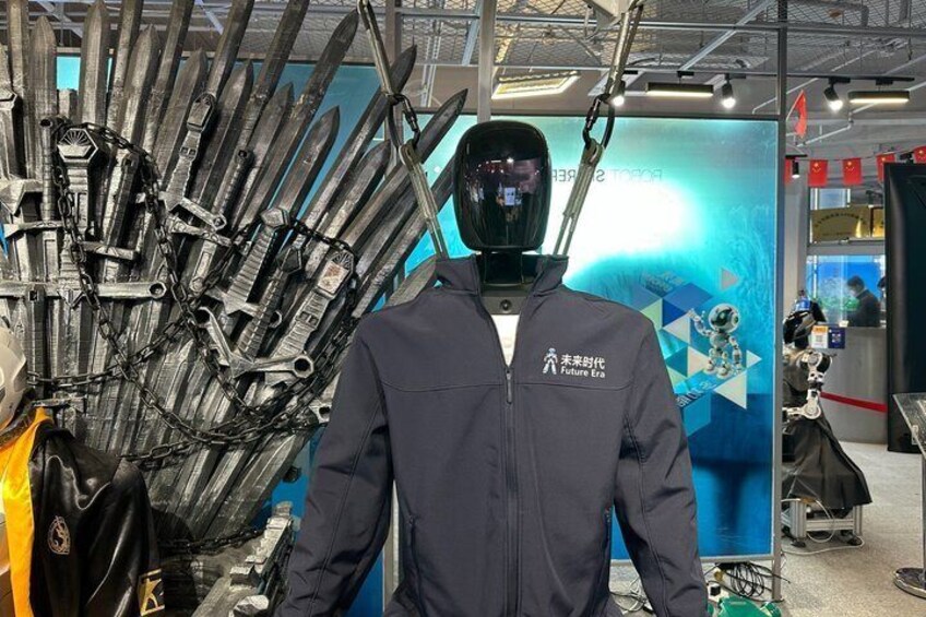 A person in a dark jacket with a helmet in front of a display of swords. 5