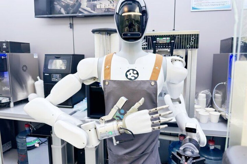 A humanoid robot in a laboratory setting with various equipment and a television in the background. 1