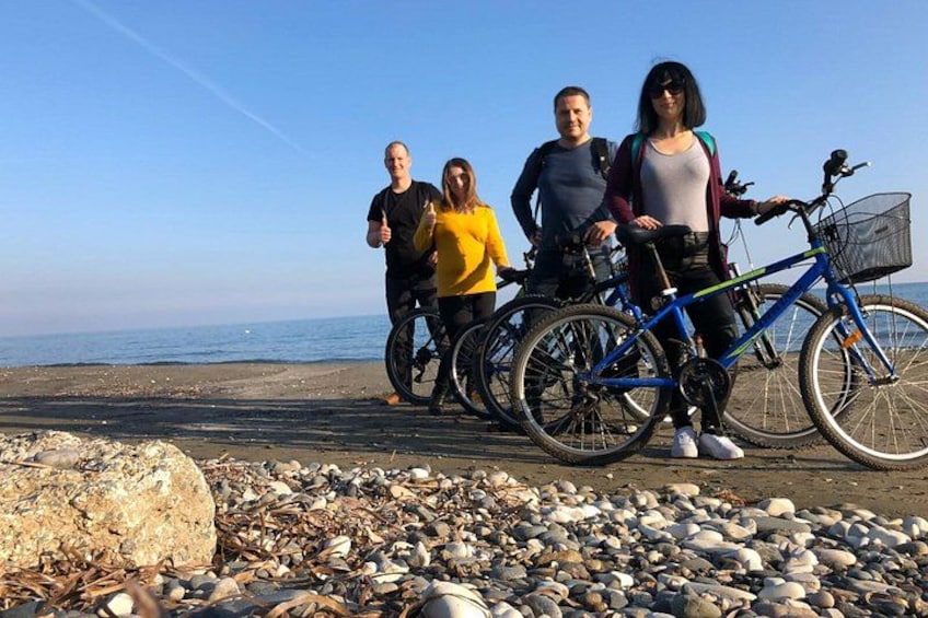 A group of people with bicycles on a rocky beach. 3