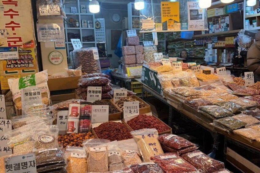 A market stall with various packaged goods, including dried fruits and nuts, with price tags visible. 4