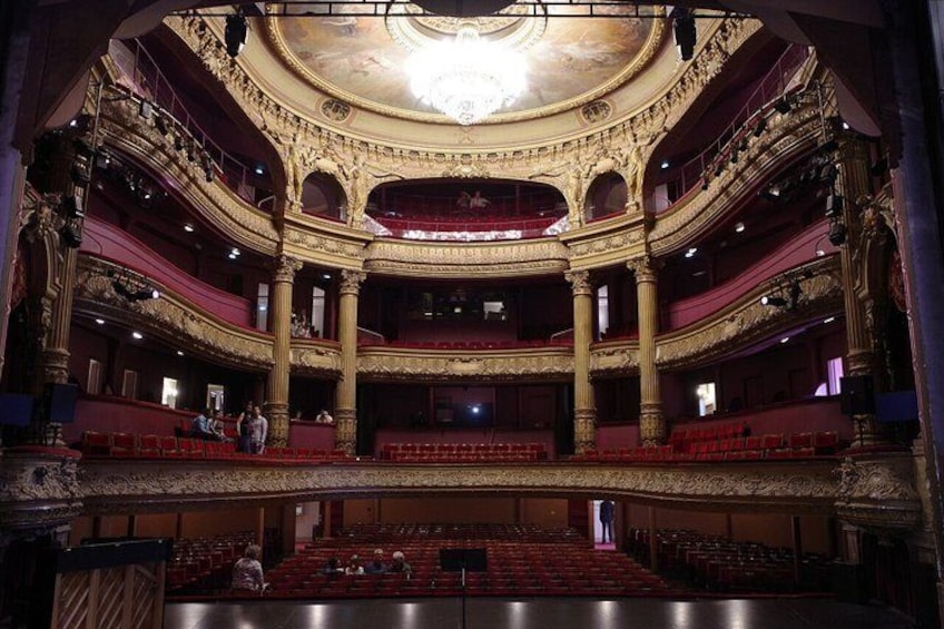 An ornate theater with multiple balconies and a grand chandelier. 5