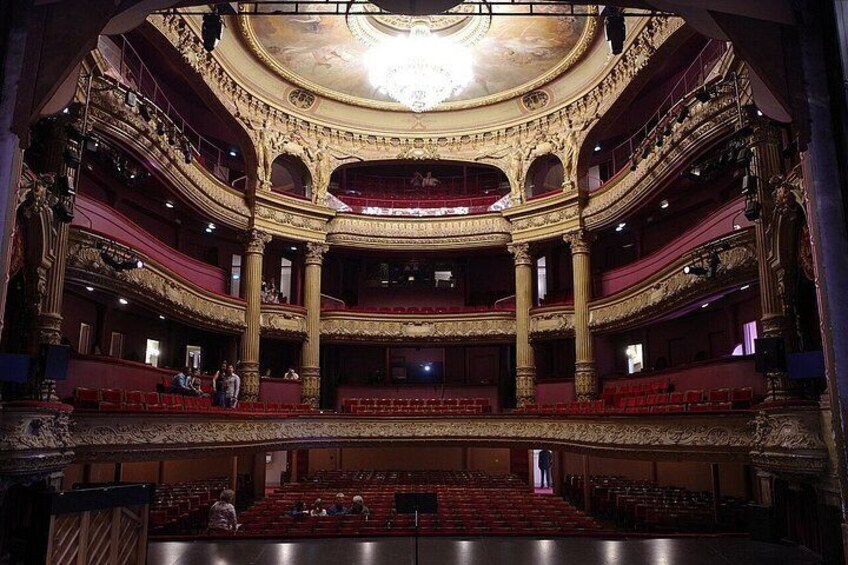 An ornate theater with multiple balconies and a central stage. 5