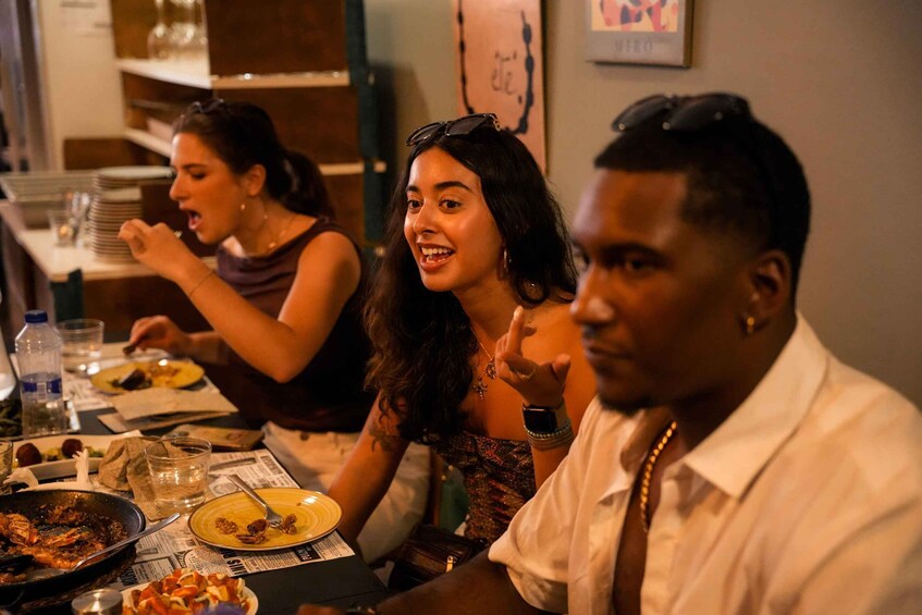 A group of people dining at a restaurant with plates of food and drinks on the table. 5