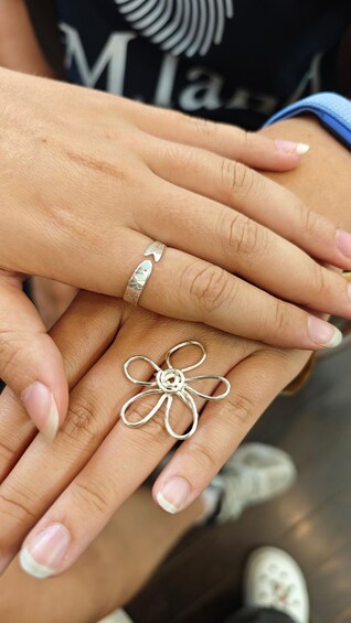 A close-up of hands wearing rings and a bracelet. 4