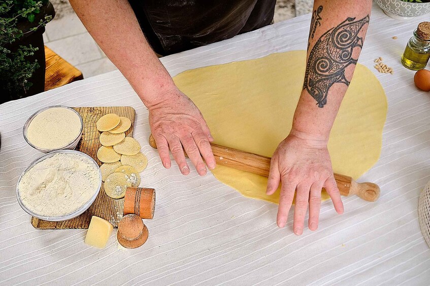 A person rolling out dough on a table with flour, tortillas, and other ingredients. 4