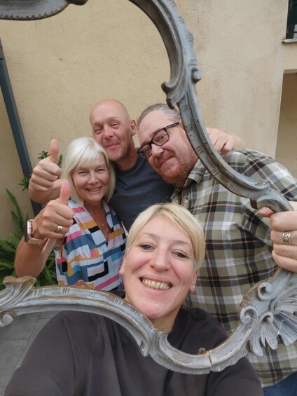 A group of people posing with a decorative mirror. 2