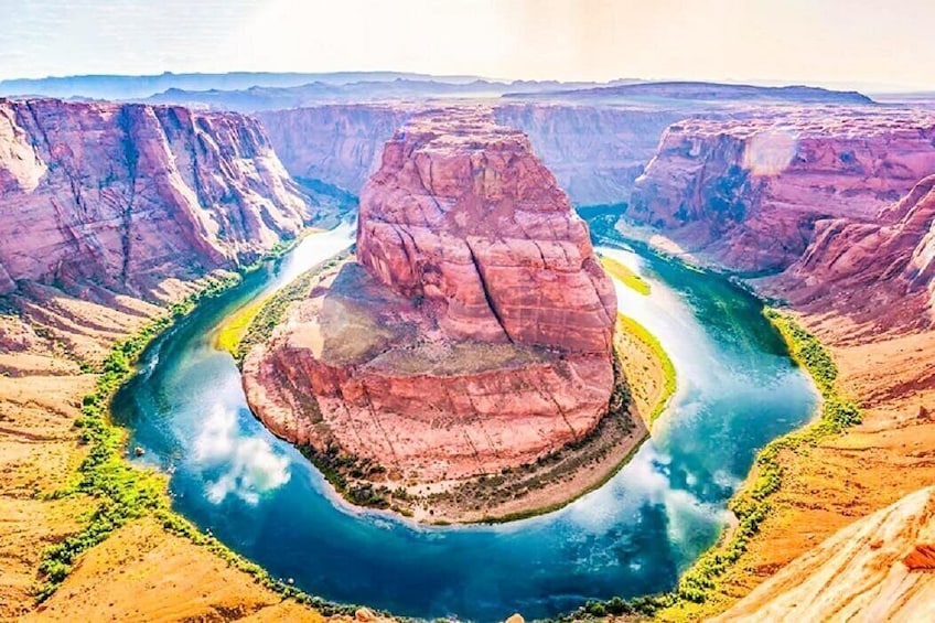 Un río serpentea por un cañón, con una destacada formación rocosa en el centro. 1