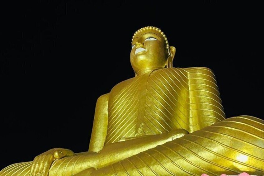 A large golden statue of a seated figure. 1