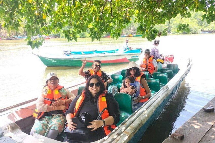 A group of people on a boat, wearing life jackets, with a river and another boat in the background. 5