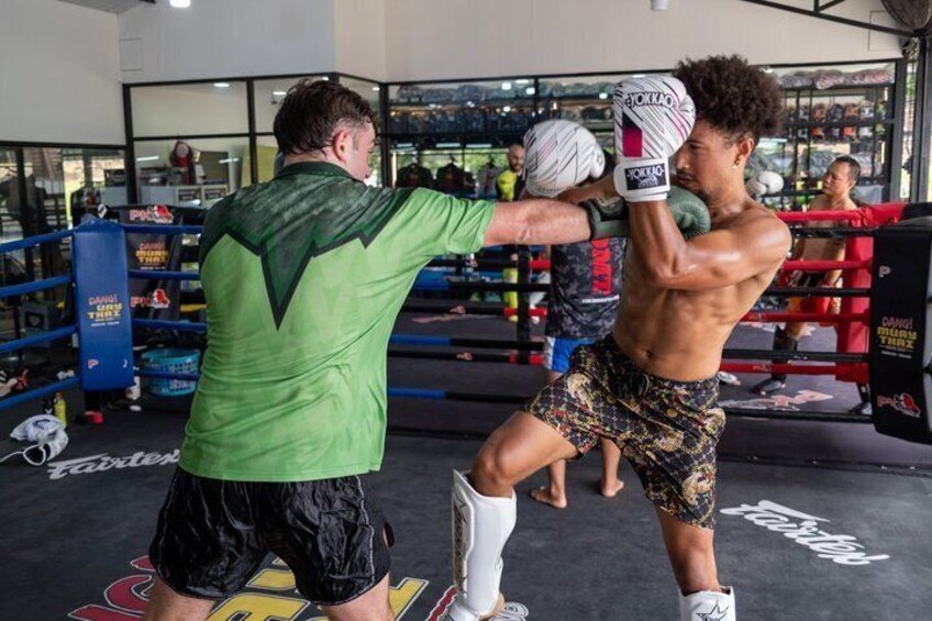 A boxing training session in a gym with boxing gloves, a punching bag, and a boxing ring. 3
