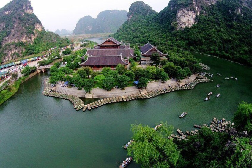 A traditional Chinese building by a river with boats docked. 4