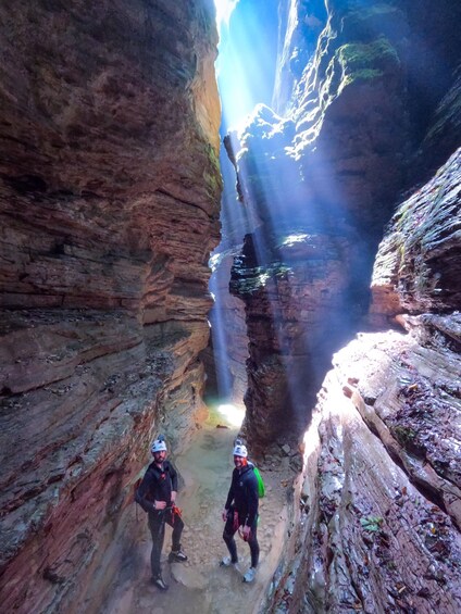 Two people in a canyon with a waterfall. 5