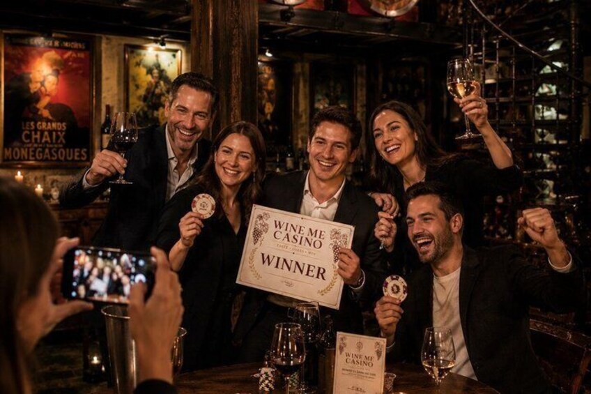 A group of people at a bar holding a sign that reads 'WINNER.' 2