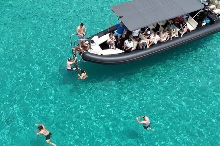 A boat with people on it in clear turquoise water. 4