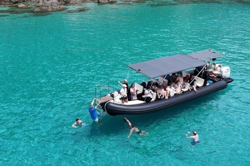 A boat with passengers in clear turquoise water. 5