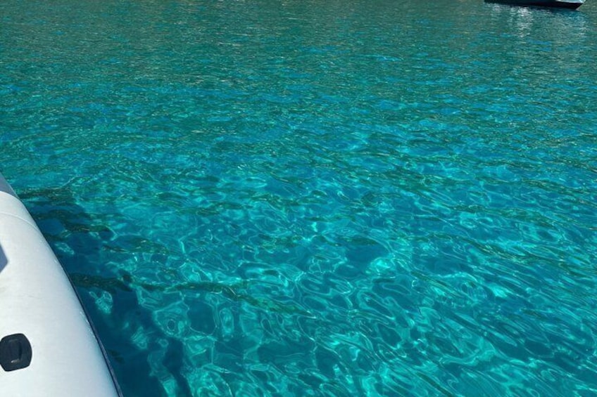 Clear turquoise water with a boat partially visible on the left. 2