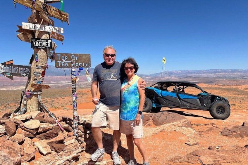 A desert landscape with a signpost, a dune buggy, and a clear sky. 5