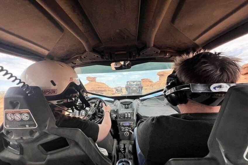 A person driving a vehicle with a steering wheel and dashboard. 5