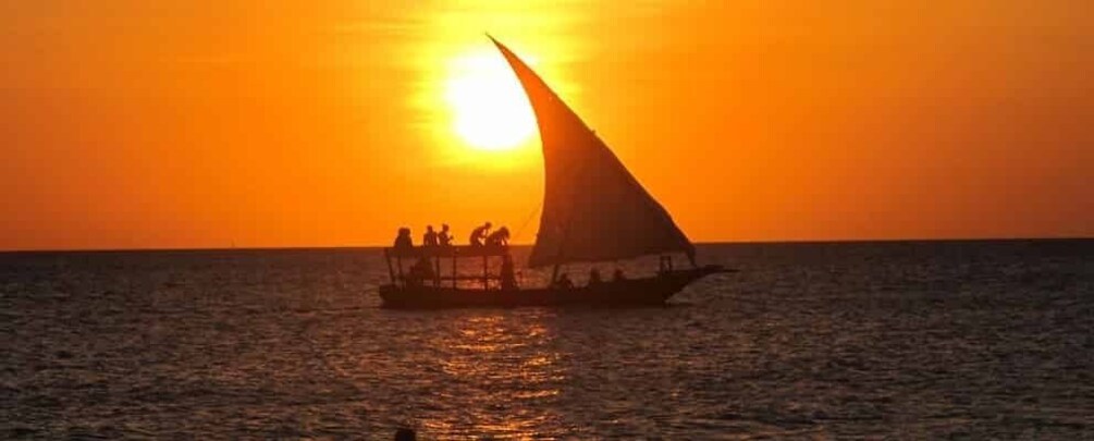 A boat with a sail on the water during sunset. 3