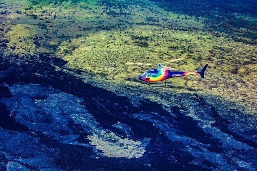 A helicopter flying over a mountainous landscape with a river below. 1