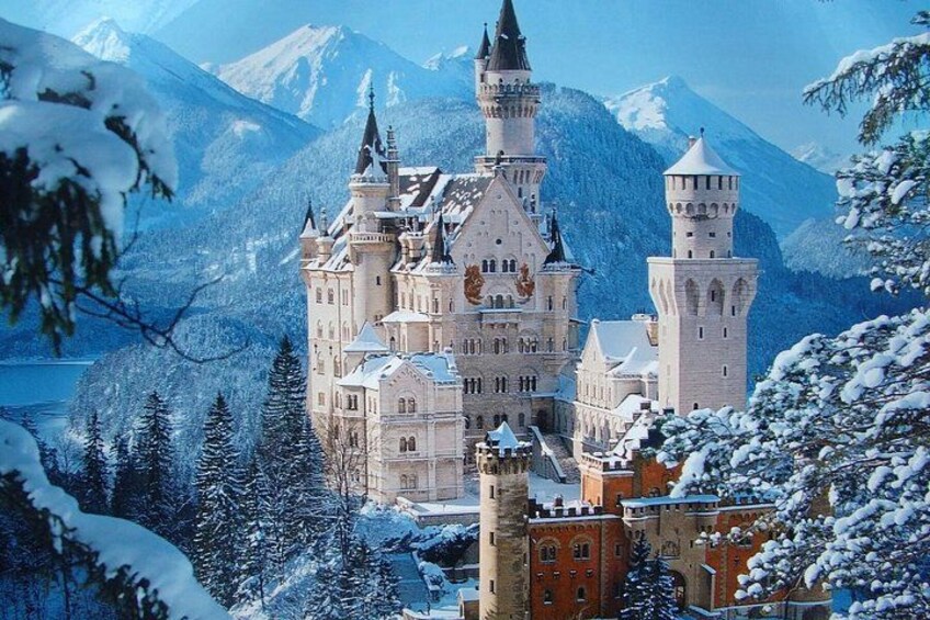 A snow-covered castle with multiple towers and a lake in the background. 3