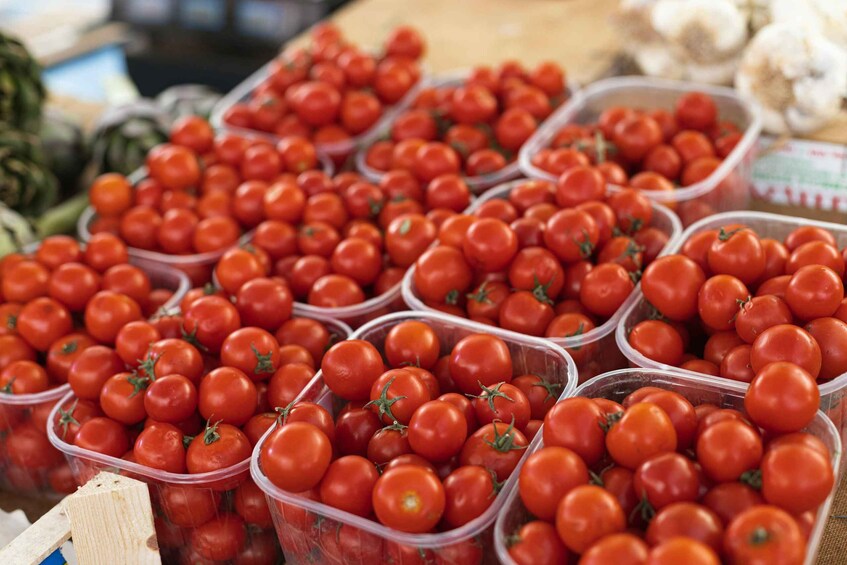 Multiple plastic containers filled with red tomatoes. 3