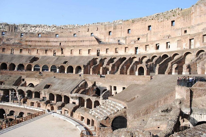 An ancient amphitheater with multiple tiers of seating and a central stage. 2