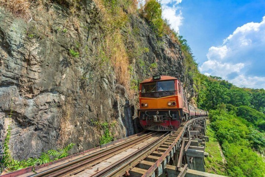 A train on a steep, narrow mountain track surrounded by lush greenery. 1