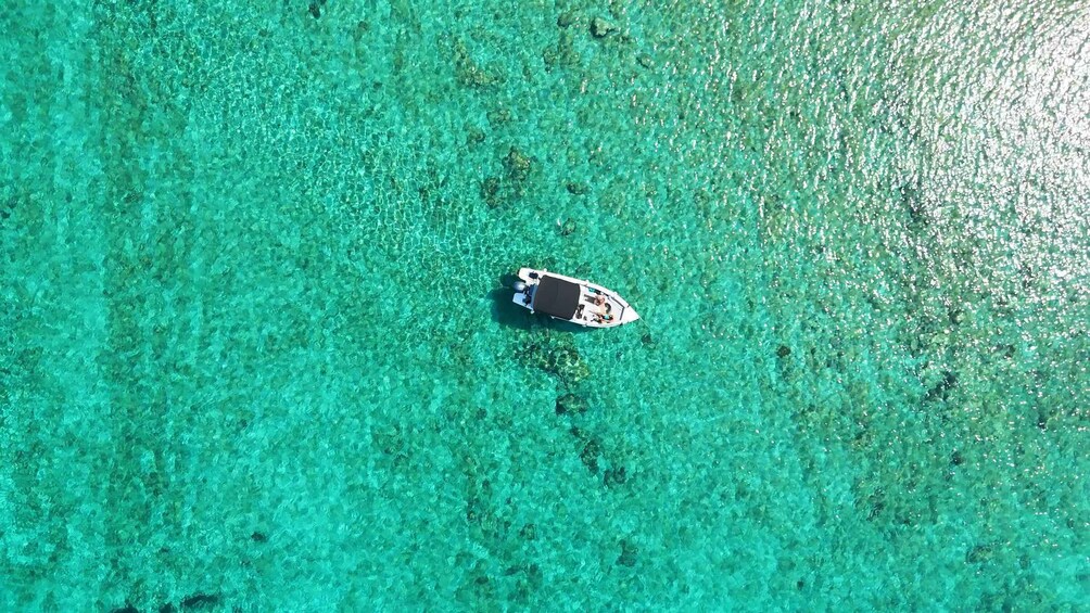 A small boat on clear turquoise water. 3