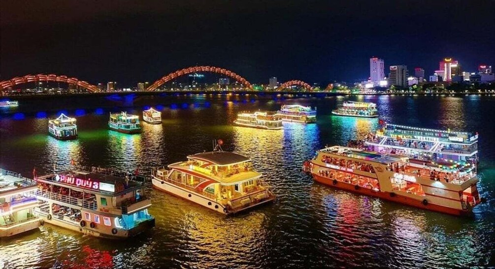 Illuminated riverboats on a river with a bridge in the background. 5